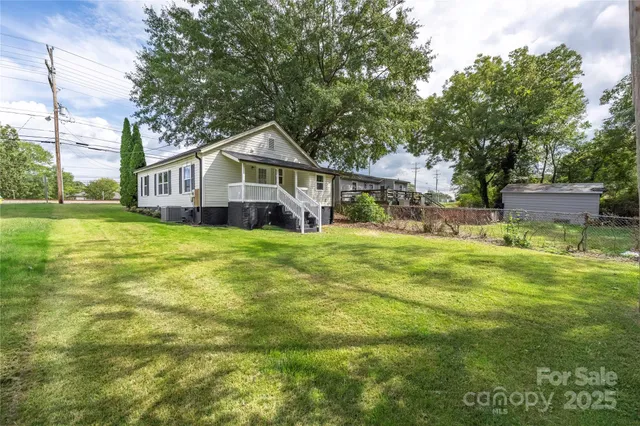 a view of a house with a big yard and large trees