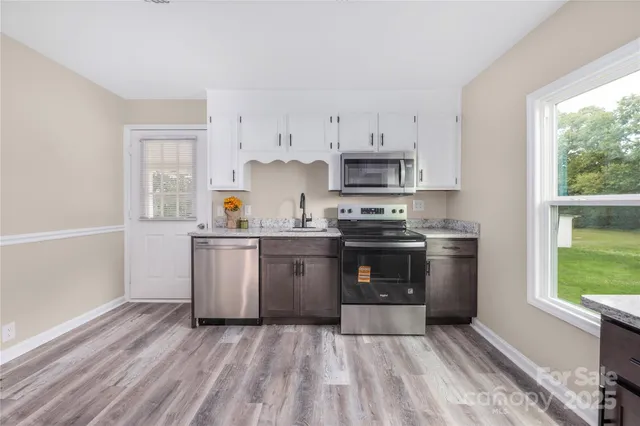 a kitchen with granite countertop a refrigerator stove top oven and sink