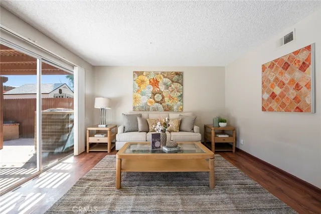 a living room with furniture a lamp and a large window with garden view
