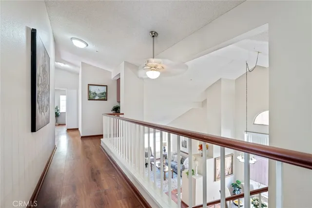 a view of a hallway with wooden floor and stairs