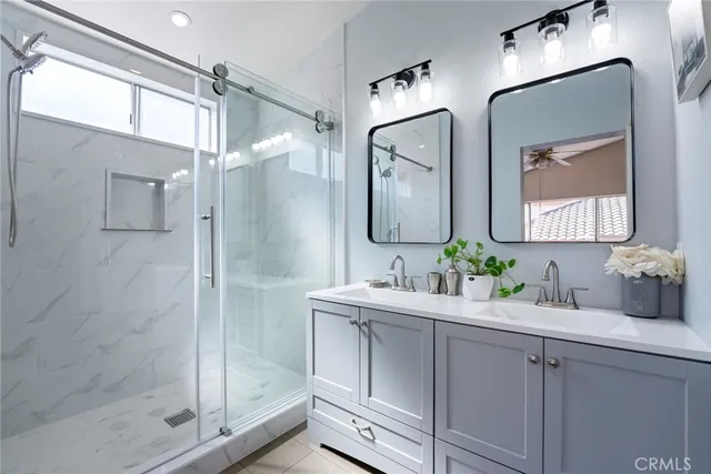 a bathroom with a double vanity sink mirror and shower