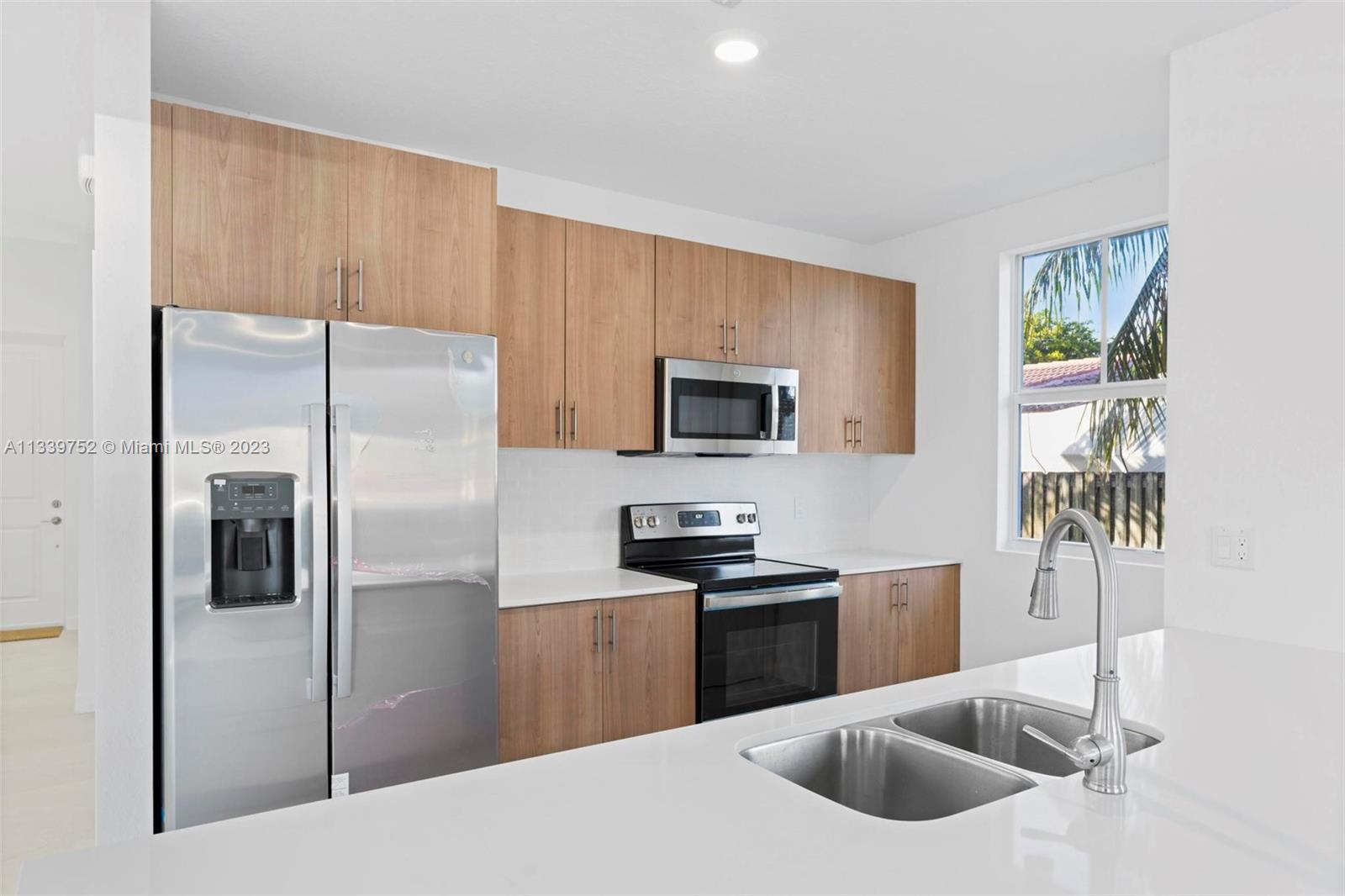 24721 Southwest 112th Court Homestead, FL 33032 - Photo 15 of 40 a kitchen with stainless steel appliances granite countertop a sink a stove and a refrigerator