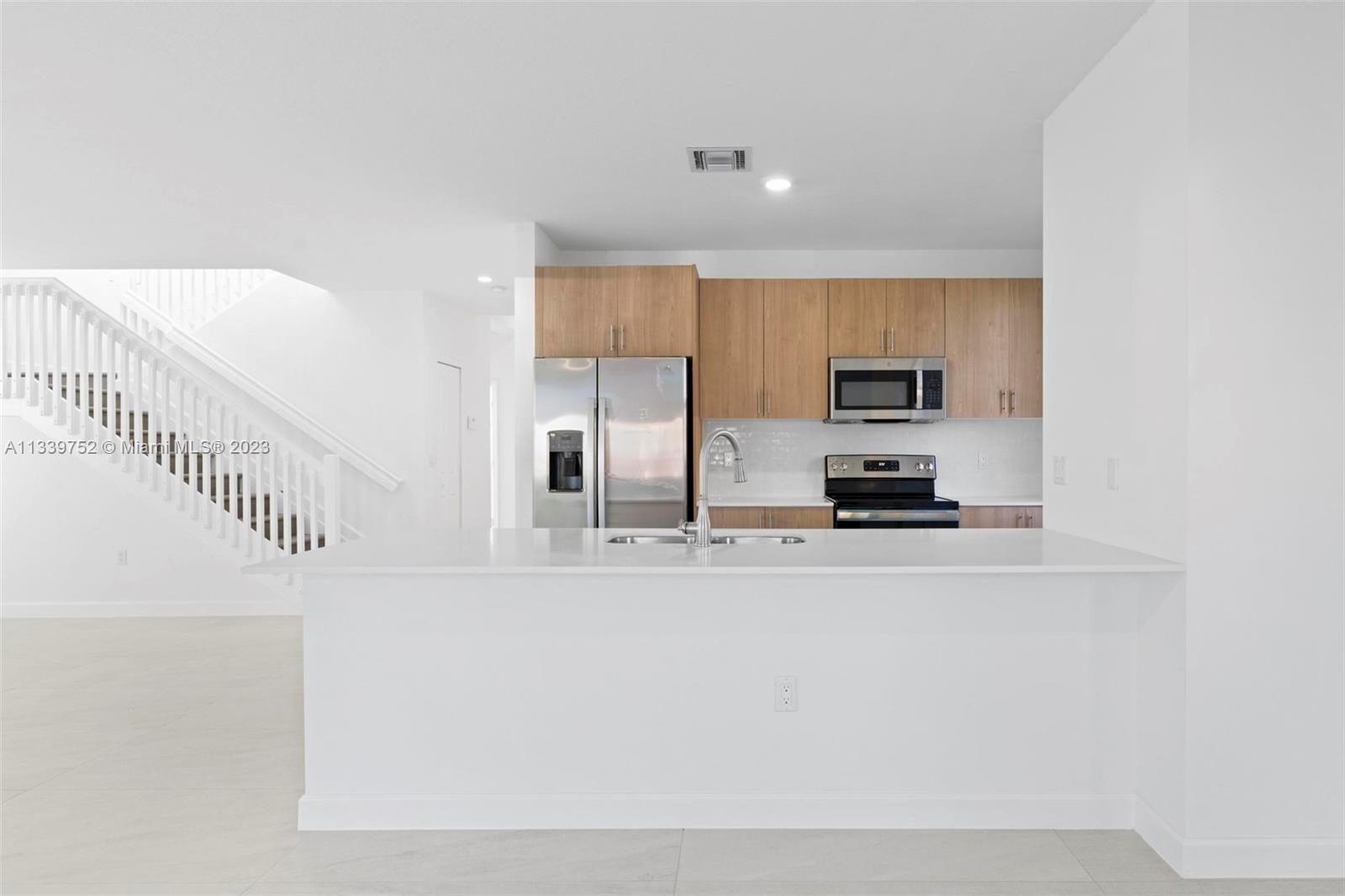 24721 Southwest 112th Court Homestead, FL 33032 - Photo 16 of 40 a kitchen with stainless steel appliances a refrigerator and a stove top oven