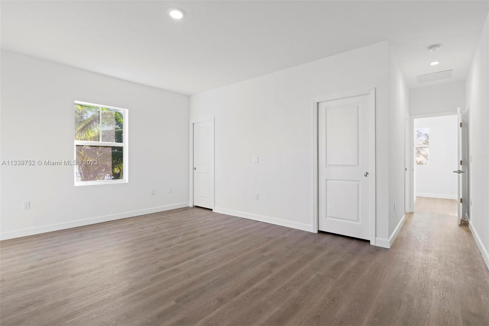 24721 Southwest 112th Court Homestead, FL 33032 - Photo 22 of 40 an empty room with wooden floor and windows
