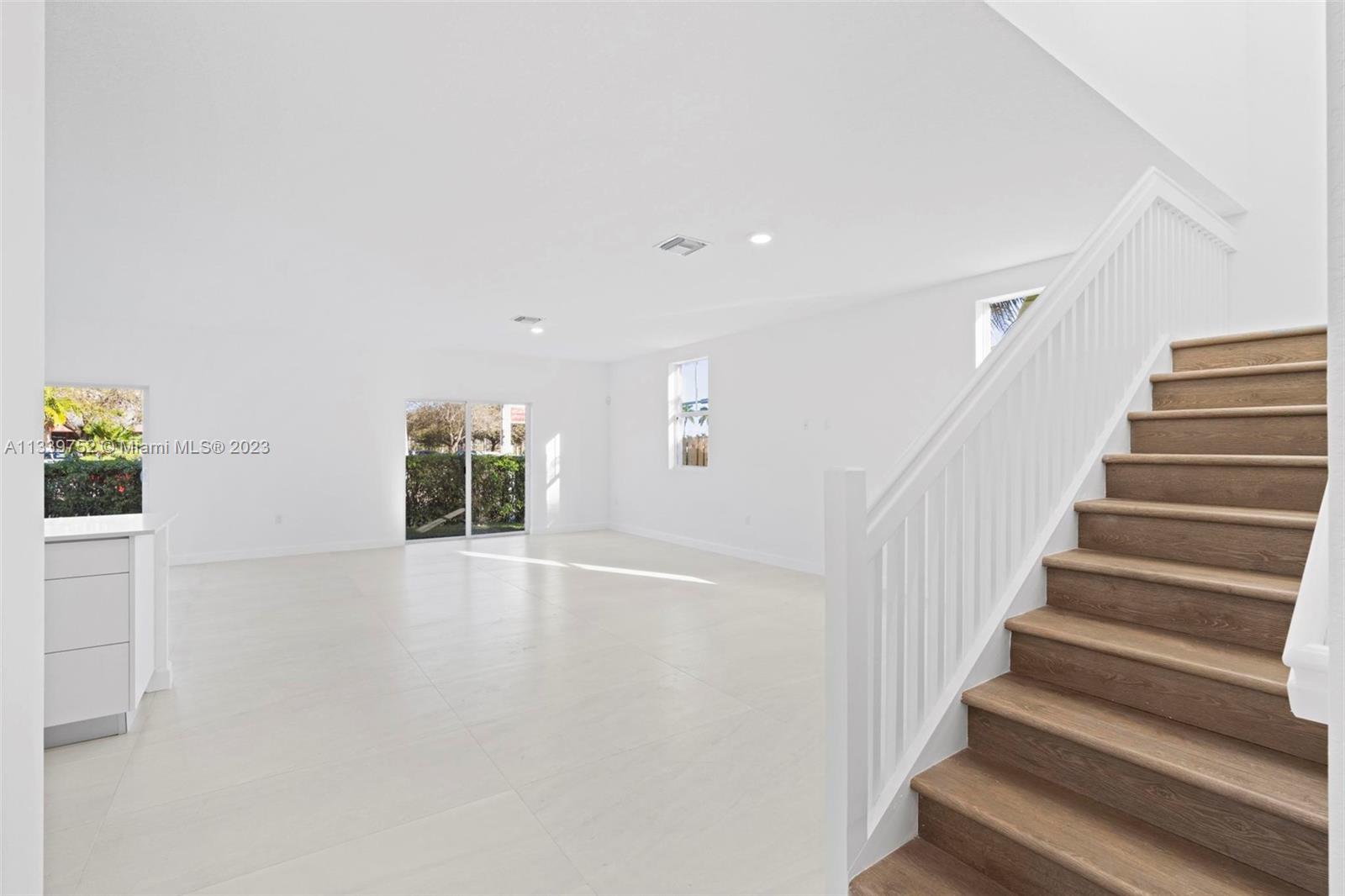24721 Southwest 112th Court Homestead, FL 33032 - Photo 6 of 40 a view of an empty room with wooden floor and stairs