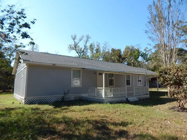 a view of a house with backyard and trees