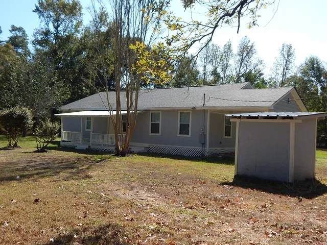 a view of a house with backyard and trees