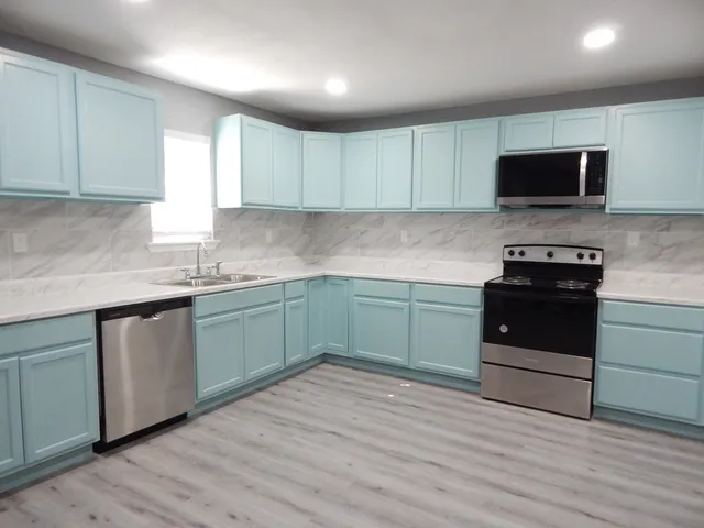 a kitchen with a sink and a stove top oven
