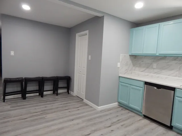 a kitchen with granite countertop a stove and a wooden floors
