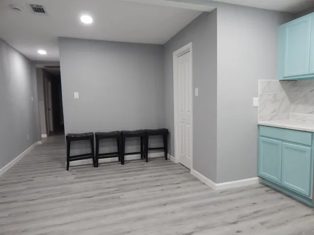 a view of a room with wooden floor and furniture