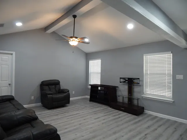 a living room with furniture and a ceiling fan