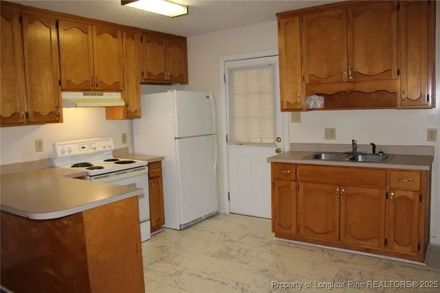 a kitchen with a refrigerator sink and cabinets