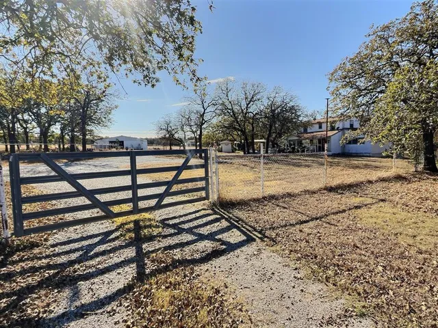 a view of a yard with wooden fence