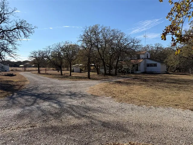 a view of dirt field with trees in the background