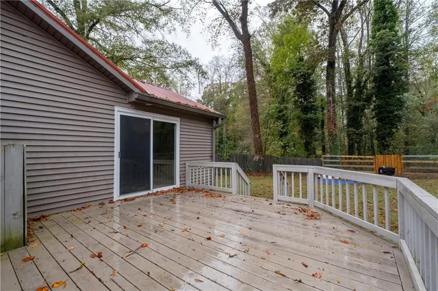 a view of backyard with large trees and wooden fence