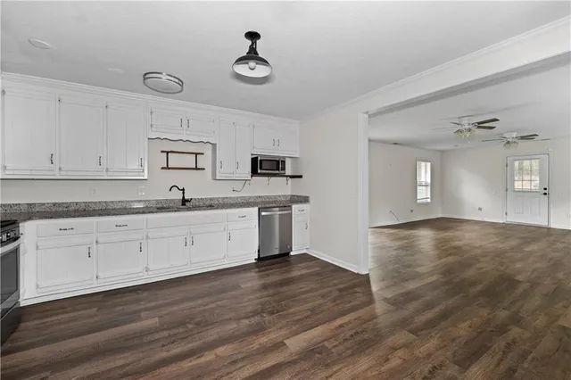 a kitchen with a sink cabinets and wooden floor