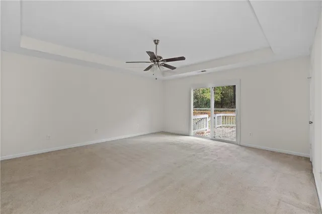 an empty room with a ceiling fan and window
