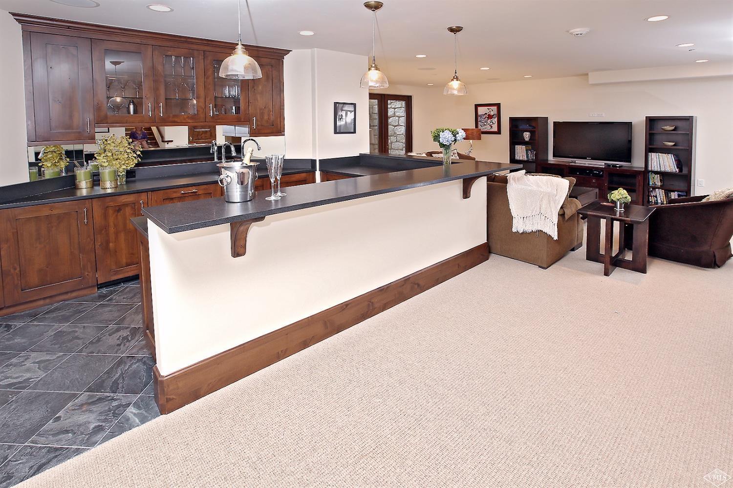 151 Vail Road, Unit 3 Vail, CO 81657 - Photo 14 of 25 a living room with kitchen island furniture and a flat screen tv