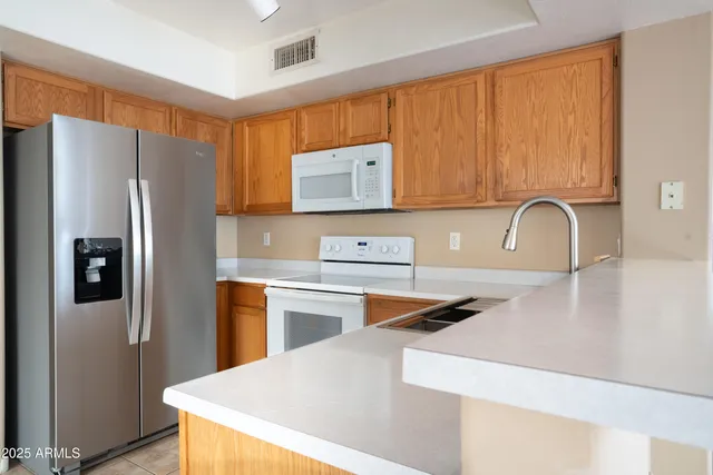 a kitchen with stainless steel appliances granite countertop a refrigerator and a stove top oven
