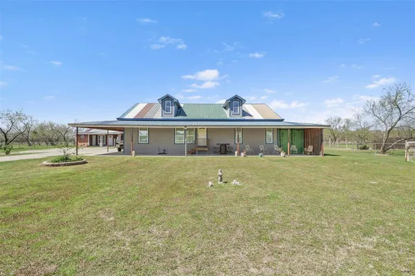 a front view of a house with a garden and yard