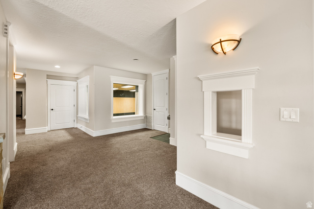 1205 North Elk Rdg Lane, Unit 202 Alpine, UT 84004 - Photo 42 of 88 Interior wall with decorative pass-through window, sconce lighting, and light-toned carpet flooring