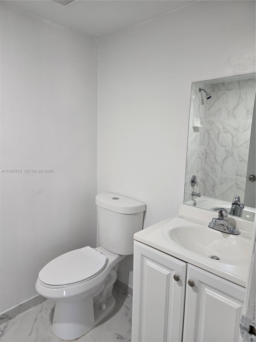 3400 Foxcroft Road, Unit 209 Miramar, FL 33025 - Photo 12 of 19 a bathroom with a sink a toilet and a mirror