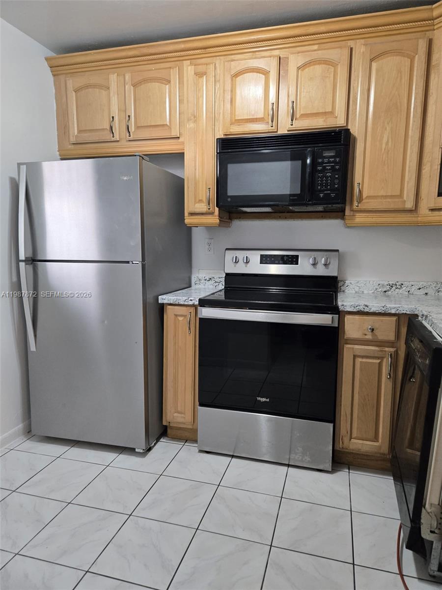 3400 Foxcroft Road, Unit 209 Miramar, FL 33025 - Photo 7 of 19 a kitchen with granite countertop a refrigerator stove and microwave