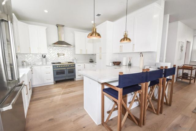 a kitchen with stainless steel appliances kitchen island granite countertop a table chairs sink and cabinets