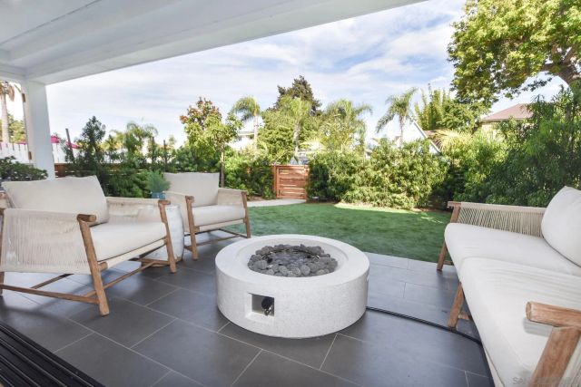 a view of a patio with furniture and a garden