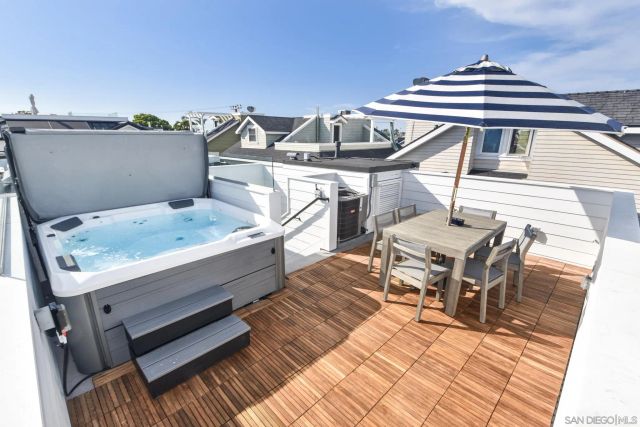 a view of a roof deck with table and chairs with wooden floor and fence