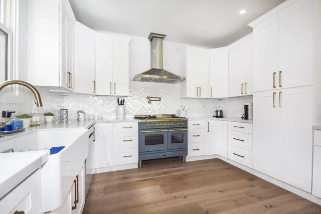 a kitchen with white cabinets stainless steel appliances and sink