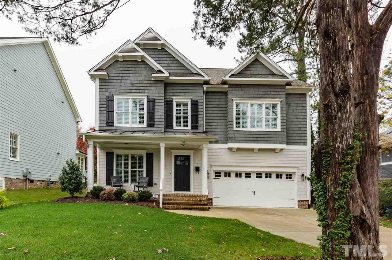 511 Mial Street Raleigh, NC 27608 - Photo 1 of 25 a view of a white house with a large window and a yard with plants and large trees
