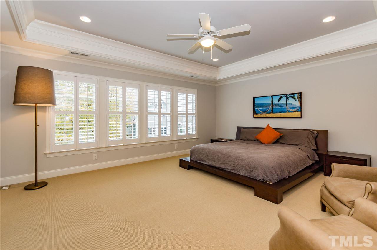 511 Mial Street Raleigh, NC 27608 - Photo 13 of 25 a bedroom with a large bed and a chandelier