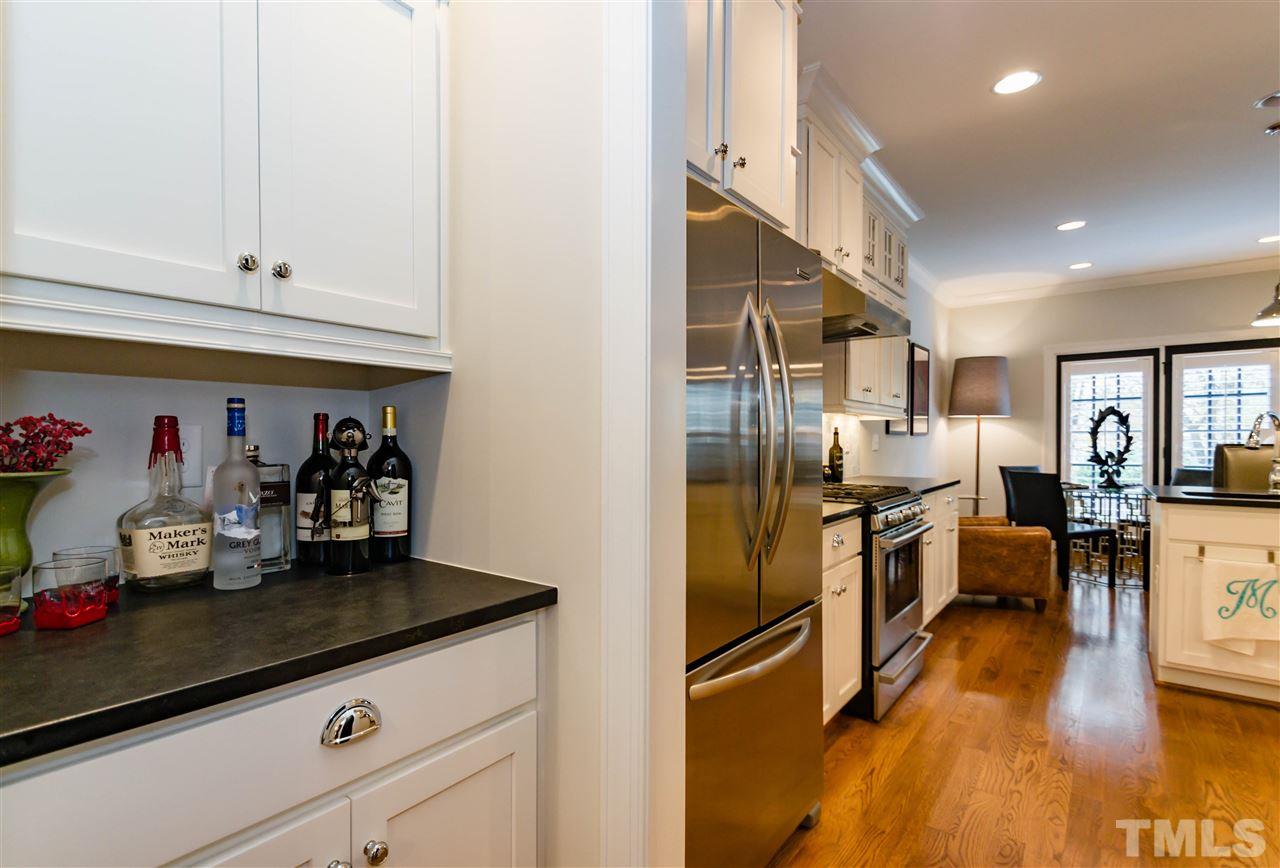 511 Mial Street Raleigh, NC 27608 - Photo 7 of 25 a kitchen with granite countertop a refrigerator a stove a sink dishwasher and white cabinets with wooden floor