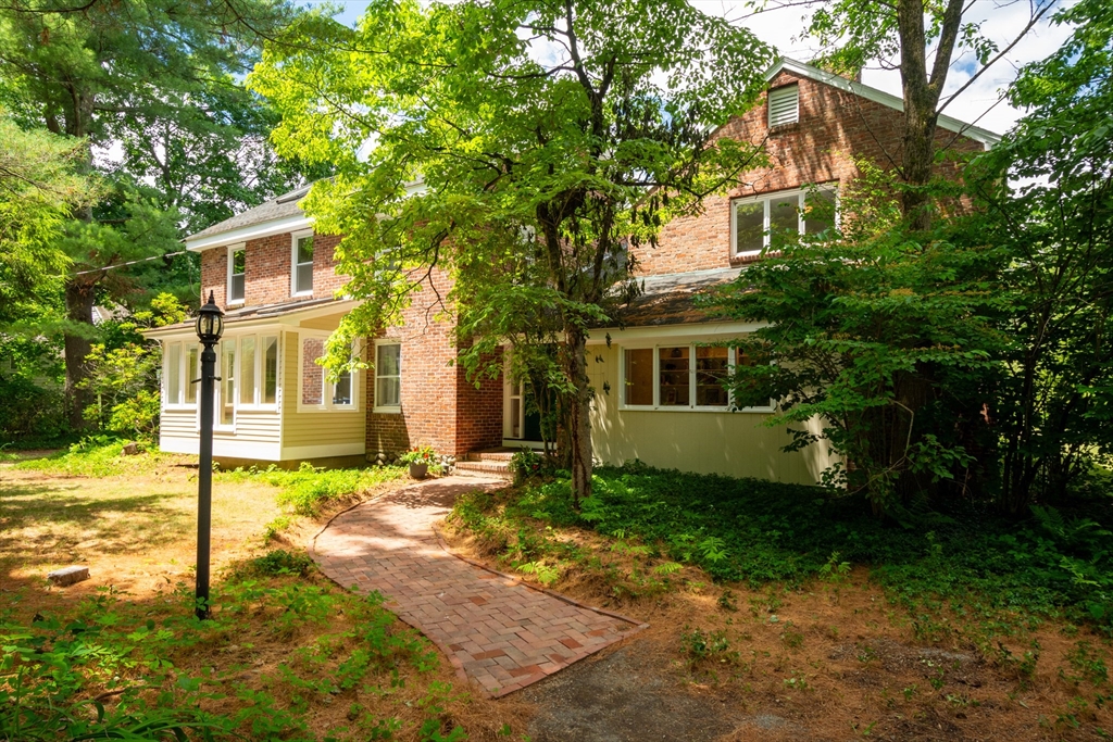a view of a yard in front of a house with a large tree