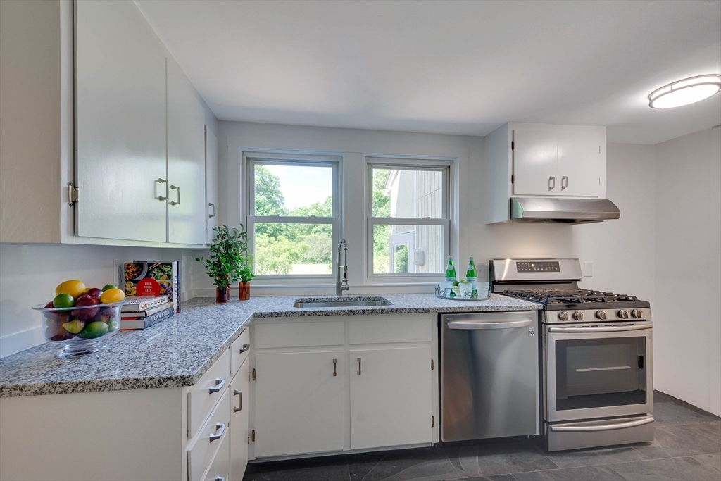 95 Tower Road Lincoln, MA 01773 - Photo 13 of 41 a kitchen with granite countertop stainless steel appliances a sink stove and window