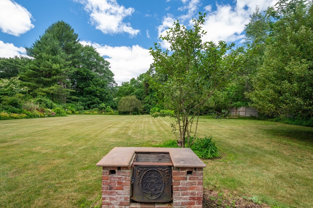 95 Tower Road Lincoln, MA 01773 - Photo 37 of 41 a view of a yard with lawn chairs plants and large trees