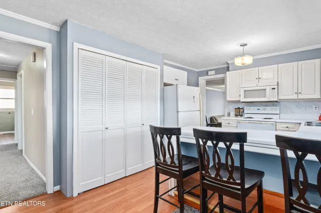 a kitchen with stainless steel appliances a dining table chairs and a refrigerator