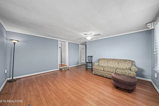 a living room with furniture and a wooden floor