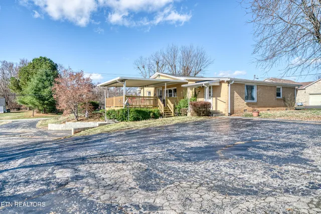a front view of a house with a yard and trees