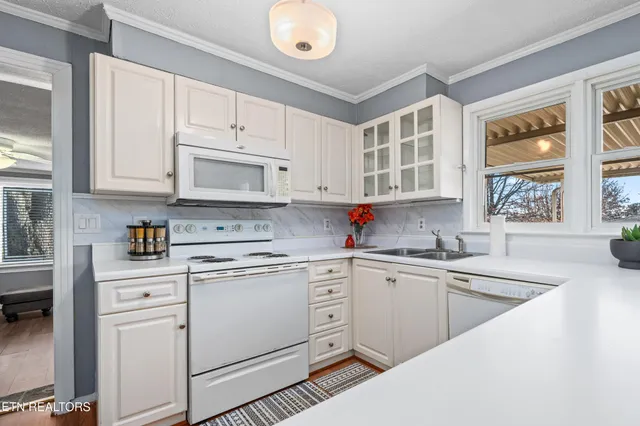 a kitchen with cabinets appliances a sink and a window