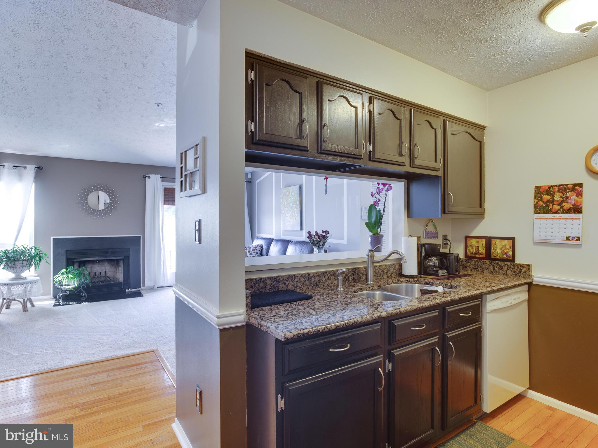 6400 Greenfield Road, Unit 908 Elkridge, MD 21075 - Photo 8 of 21 Granite counters and wood flooring in the kitchen