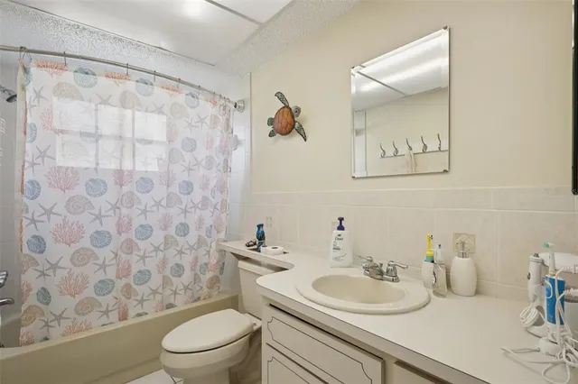a bathroom with a sink a toilet and a shower curtain