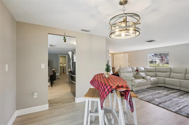 a kitchen with a sink dishwasher and white cabinets with wooden floor