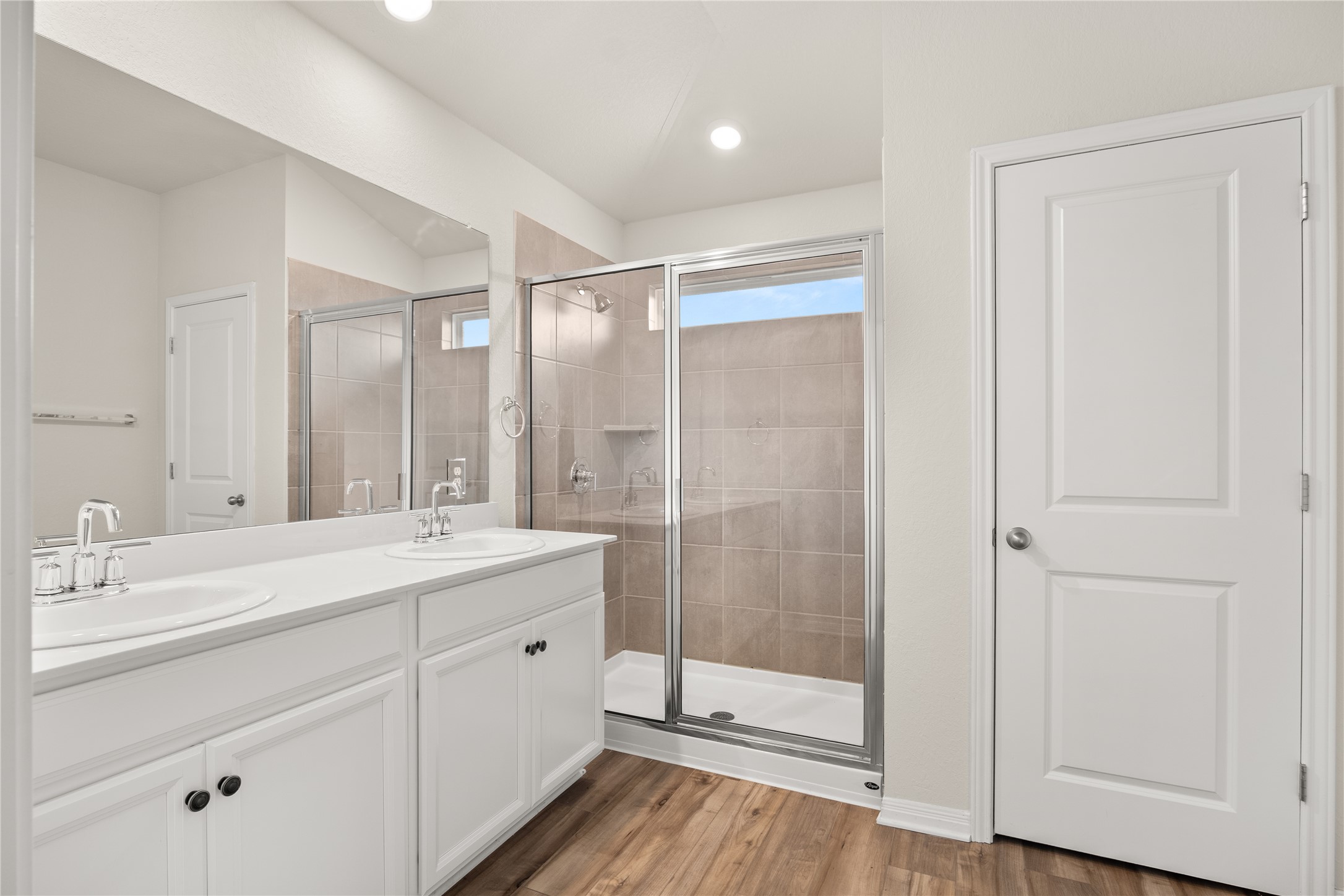 105 Saviano Road Hutto, TX 78634 - Photo 11 of 22 A well-lit bathroom features a spacious shower and a wide vanity with dual sinks.