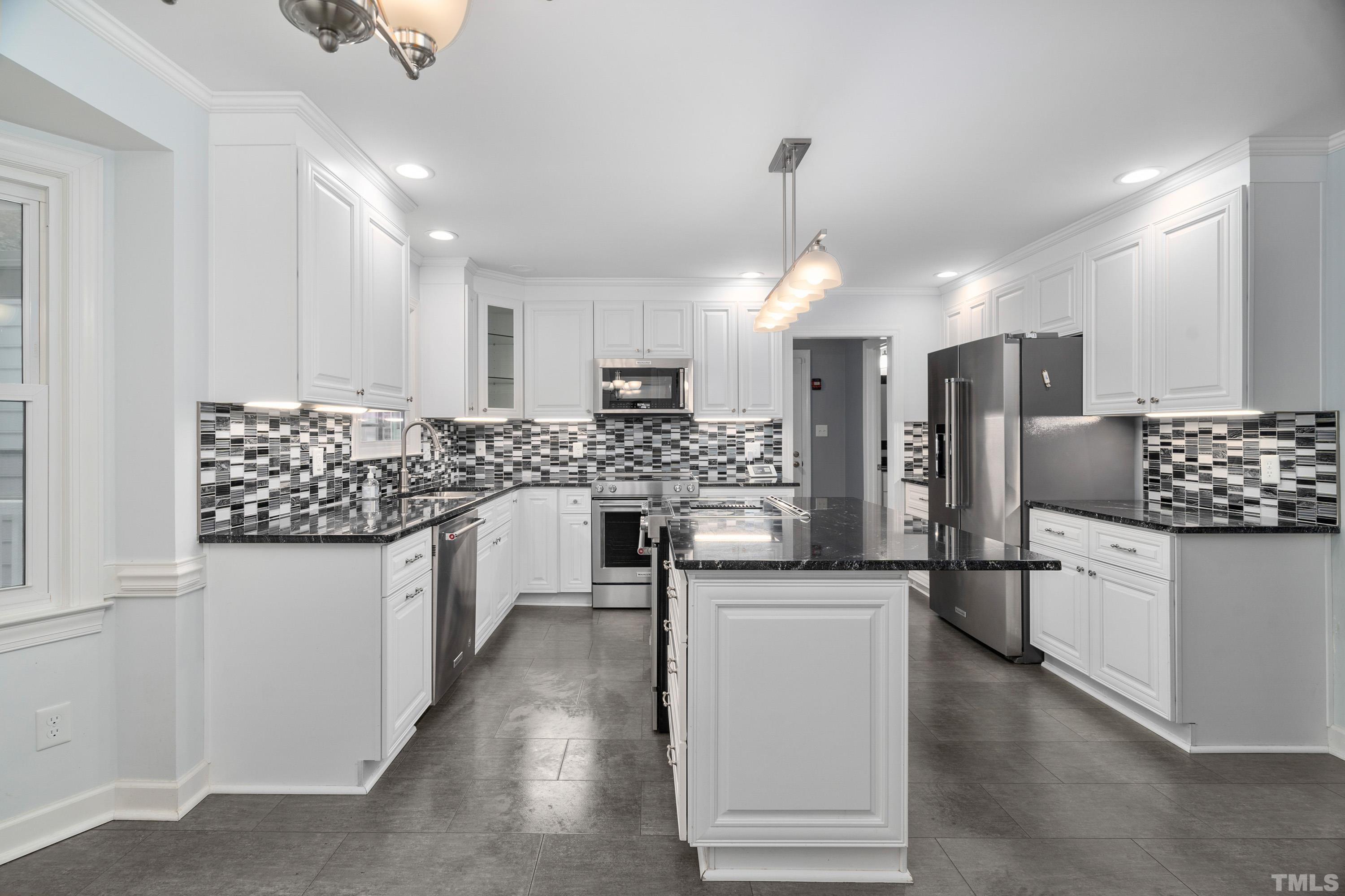 2013 Countrywood Road North Raleigh, NC 27615 - Photo 16 of 73 a kitchen with stainless steel appliances kitchen island granite countertop a refrigerator and a stove top oven