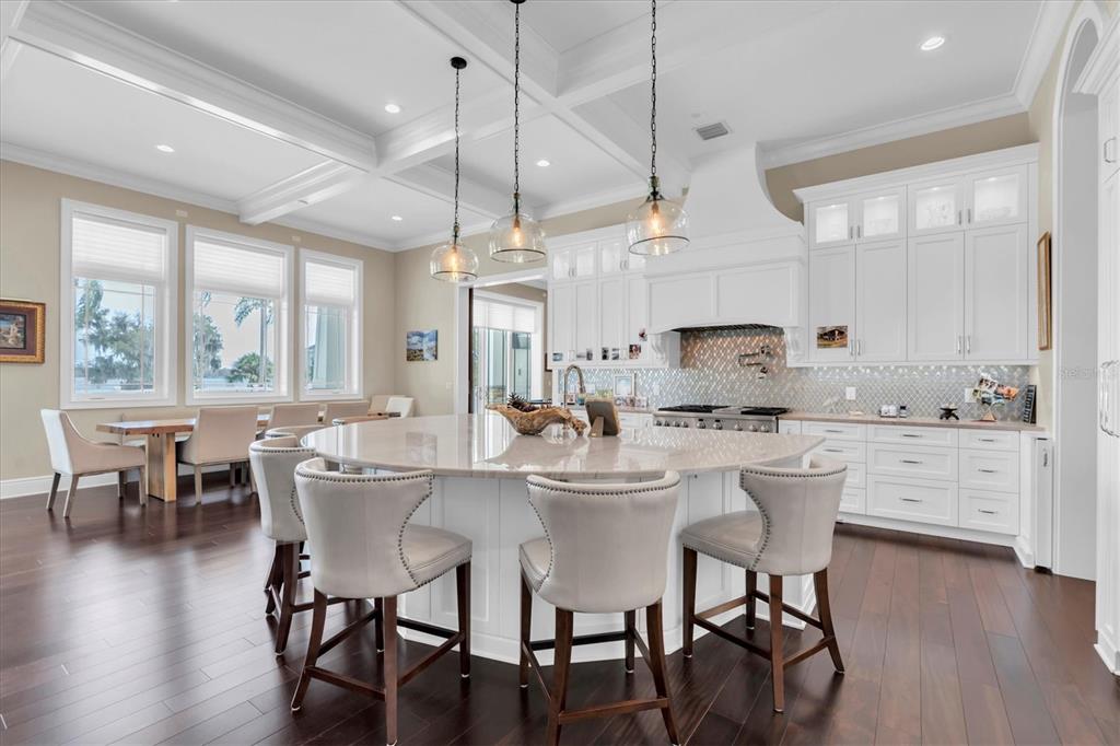 4650 Ridgeview Road Palm Harbor, FL 34684 - Photo 17 of 100 a kitchen with a dining table chairs wooden floor cabinets and stainless steel appliances