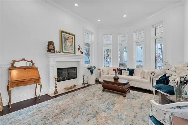 a living room with furniture kitchen view and a wooden floor