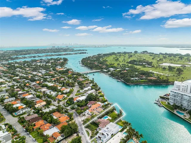 an aerial view of ocean and residential houses with outdoor space