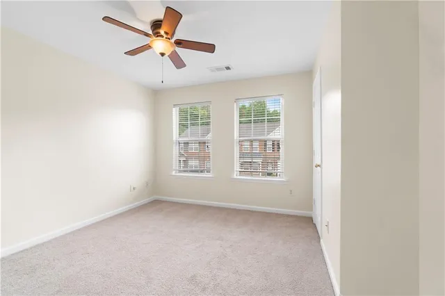 an empty room with a window and a fan